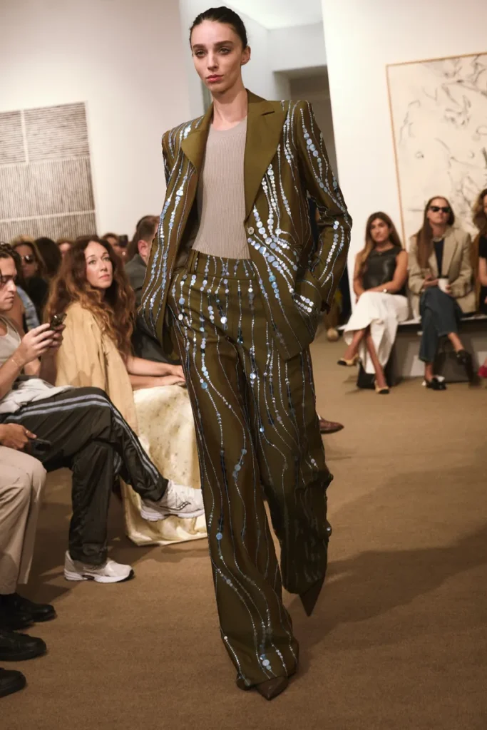 مدل با کت‌وشلوار سبز زیتونی تزئین‌شده با پولک‌های درخشان از مجموعه بهار ۲۰۲۶ Amir Taghi در NYFW