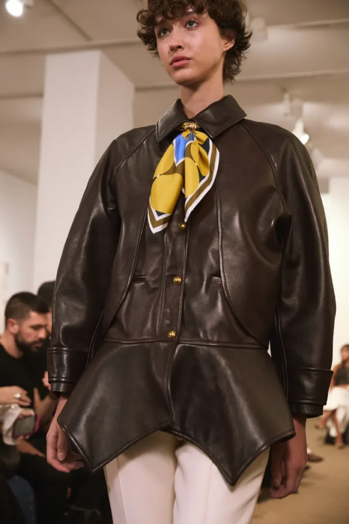 کت چرمی قهوه‌ای با شال ابریشمی زرد از مجموعه بهار ۲۰۲۶ Amir Taghi در New York Fashion Week